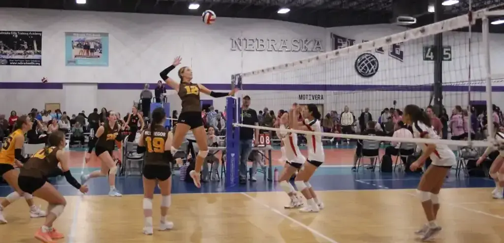 Competitive girls volleyball game with athletes in action at the net Competitive girls volleyball game with athletes in action at the net