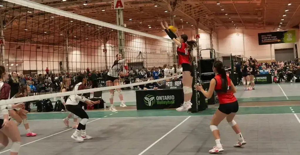 Girls volleyball players in action at the net during a championship tournament Girls volleyball players in action at the net during a championship tournament